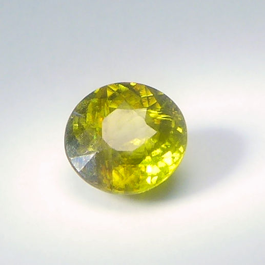 Bild 1 von 1.00 ct.  Natürlicher runder gelblich grüner 6 mm Madagaskar Titanit Sphen